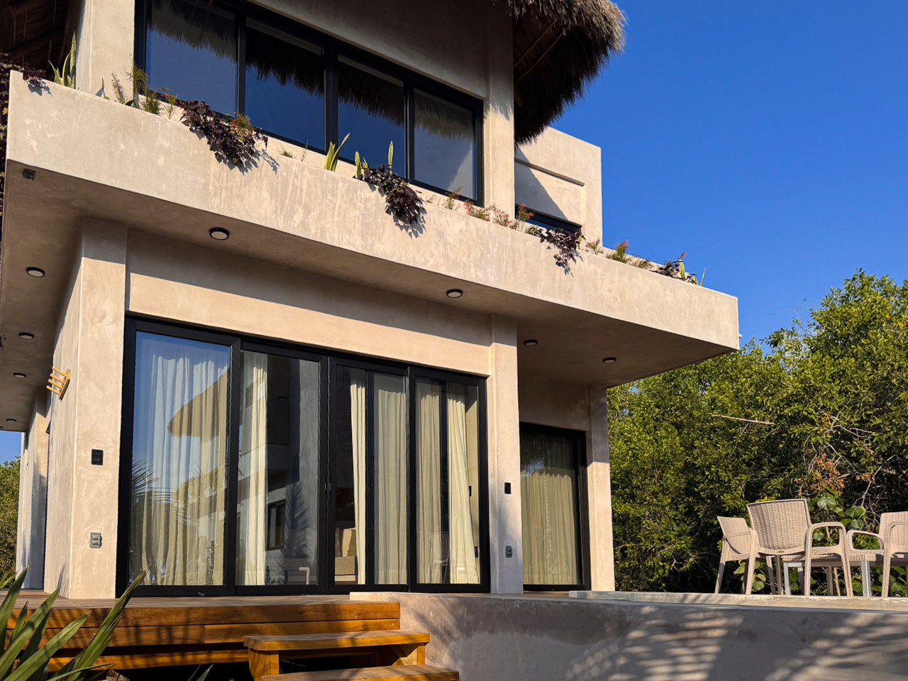 Vista lateral de la casa con terraza y asoleadero