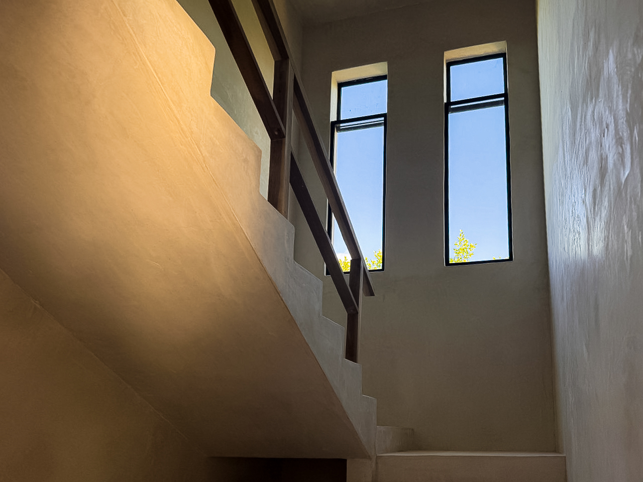 Escalera de concreto con ventanales hacia la vegetación