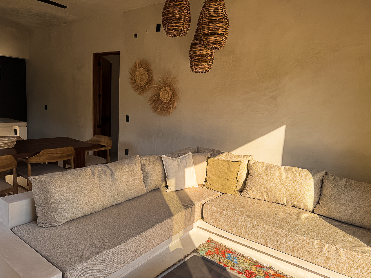 Sala con sofá en L y lámparas tejidas